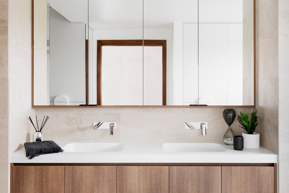 This is an example of a mid-sized traditional master bathroom in Melbourne with flat-panel cabinets, dark wood cabinets, a drop-in tub, an alcove shower, a two-piece toilet, ceramic tile, beige walls, ceramic floors, an integrated sink, laminate benchtops, beige floor, an open shower and white benchtops.