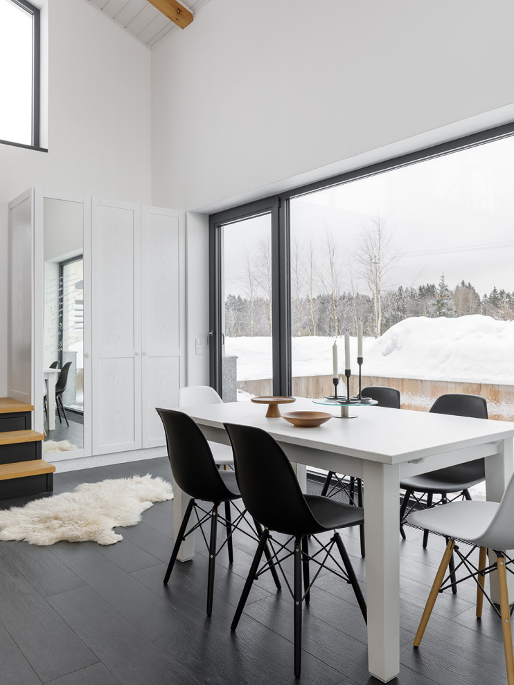 Идея дизайна: гостиная-столовая среднего размера в скандинавском стиле с белыми стенами, полом из керамогранита, стандартным камином, фасадом камина из металла, черным полом, балками на потолке и обоями на стенах