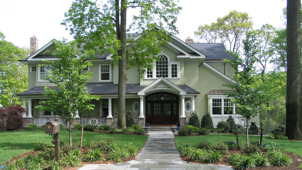 Large traditional two-storey green house exterior in New York with wood siding and a shingle roof.