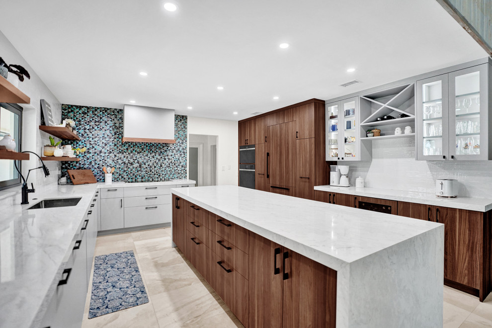 Photo of a modern kitchen/diner with flat-panel cabinets, medium wood cabinets, blue splashback, an island and white worktops.