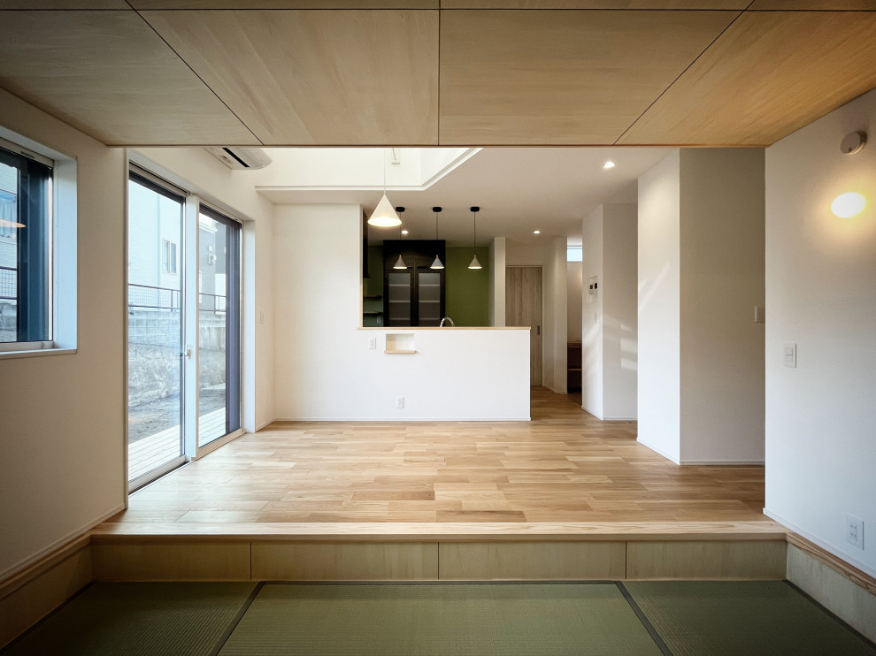 Bild på ett litet allrum med öppen planlösning, med vita väggar, tatamigolv, en fristående TV och beiget golv