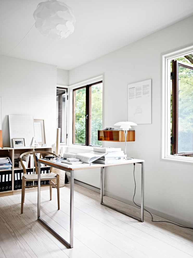 Inspiration for a mid-sized scandinavian home office in Copenhagen with white walls, light hardwood floors and a freestanding desk.