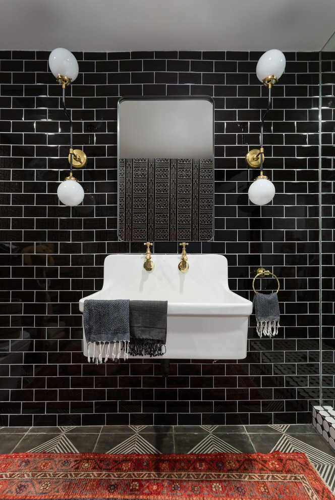 Photo of a contemporary bathroom in Los Angeles with black tile, subway tile, a wall-mount sink and grey floor.