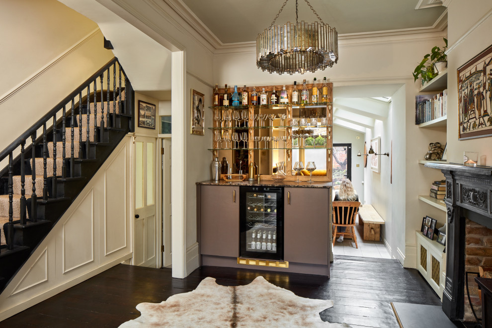 Photo of a small transitional single-wall home bar in London with glass-front cabinets, brown cabinets, granite benchtops, glass sheet splashback, dark hardwood floors, brown floor and multi-coloured benchtop.