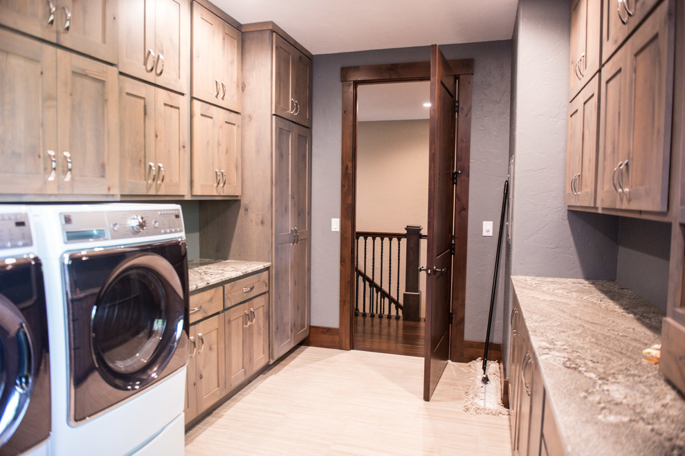 Huge mountain style u-shaped gray floor utility room photo with an undermount sink, flat-panel cabinets, light wood cabinets, granite countertops, blue walls, a side-by-side washer/dryer and multicolored countertops
