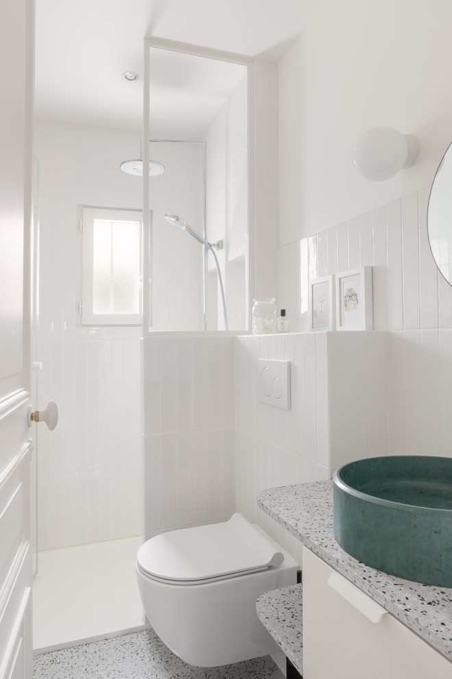 This is an example of a small transitional kids bathroom in Paris with an open shower, white walls, terrazzo floors, a console sink and a hinged shower door.