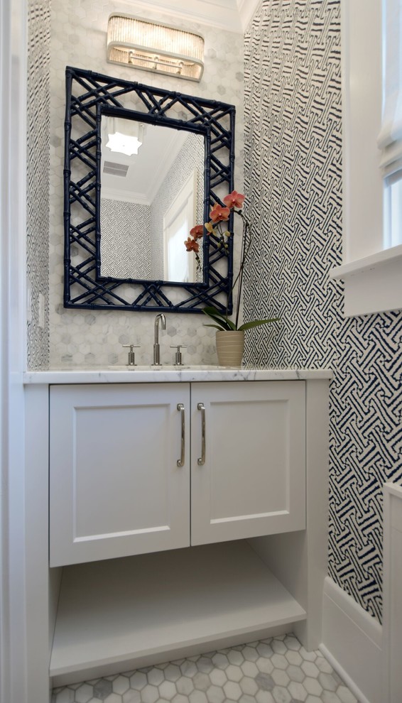 This is an example of a small transitional powder room in New York with white cabinets, white tile, porcelain tile, multi-coloured walls, marble floors, an undermount sink, marble benchtops, white benchtops and shaker cabinets.