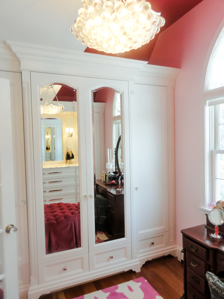 Design ideas for a mid-sized transitional women's dressing room in Burlington with recessed-panel cabinets, white cabinets and medium hardwood floors.