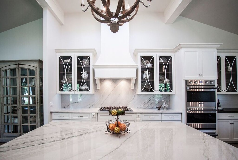 Large transitional galley light wood floor eat-in kitchen photo in Chicago with a farmhouse sink, flat-panel cabinets, white cabinets, quartzite countertops, gray backsplash, stone slab backsplash, stainless steel appliances and an island