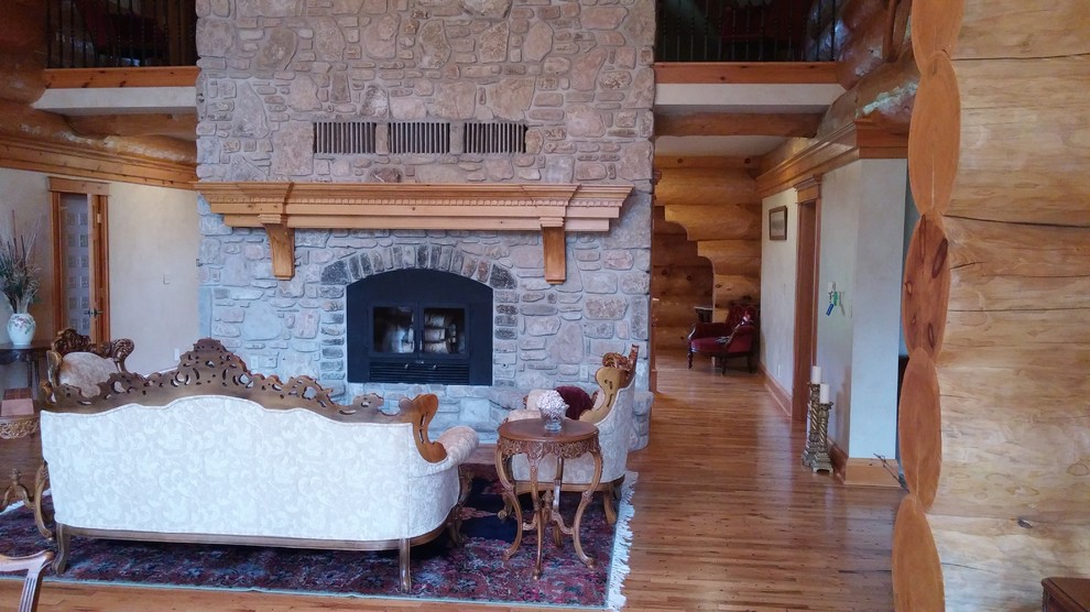 Home design - huge rustic open concept medium tone wood floor home design idea with white walls, a two-sided fireplace and a stone fireplace