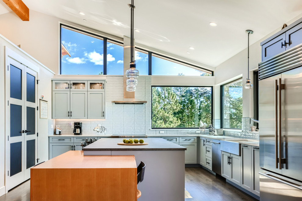 Inspiration for a large modern u-shaped light wood floor, brown floor and vaulted ceiling eat-in kitchen remodel in Denver with an undermount sink, recessed-panel cabinets, gray cabinets, quartzite countertops, white backsplash, porcelain backsplash, stainless steel appliances, an island and white countertops
