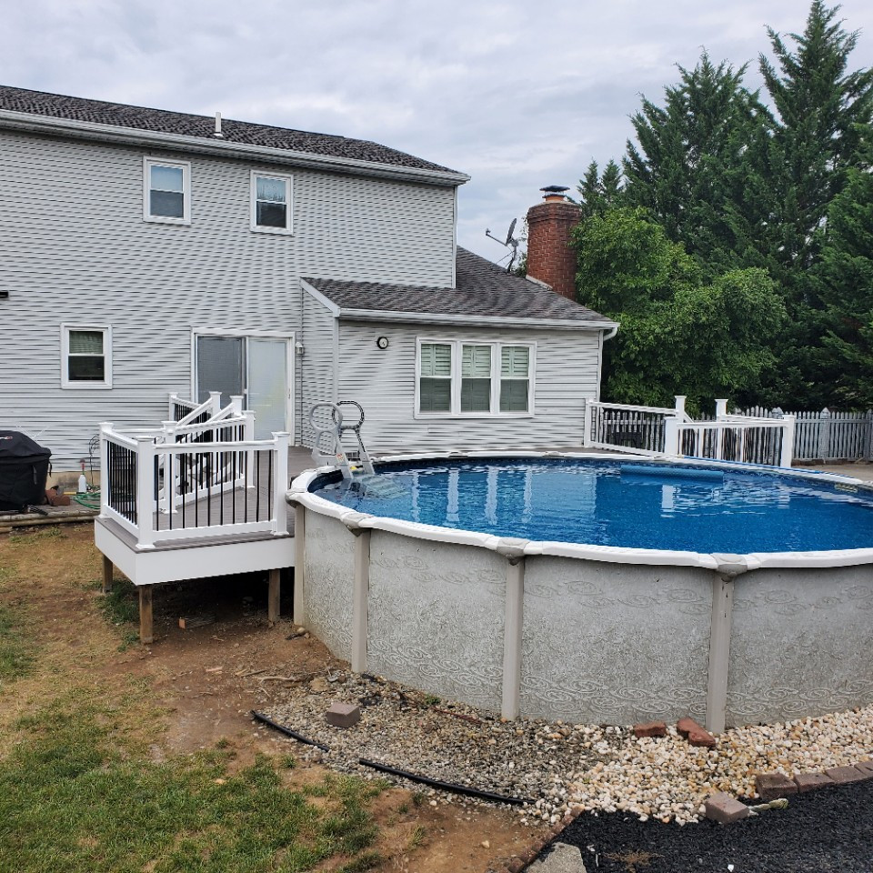 Imagen de piscina elevada clásica renovada de tamaño medio redondeada en patio trasero con entablado