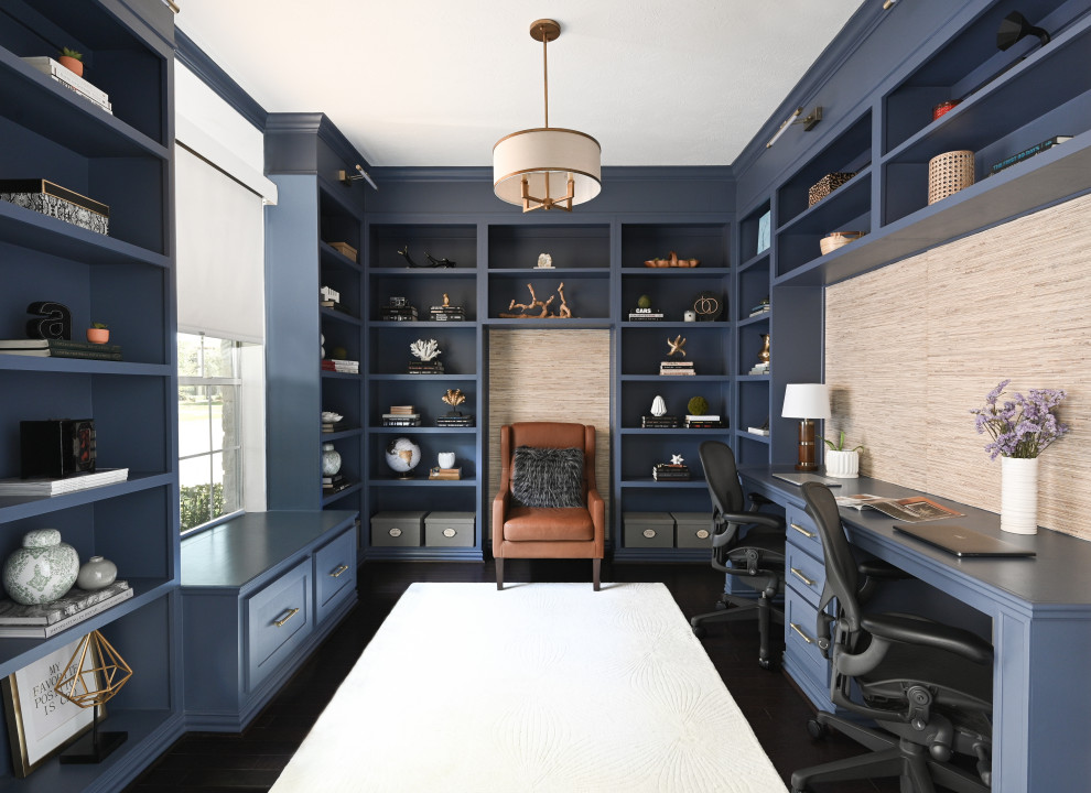 Inredning av ett maritimt litet hemmabibliotek, med blå väggar, mörkt trägolv, ett inbyggt skrivbord och brunt golv