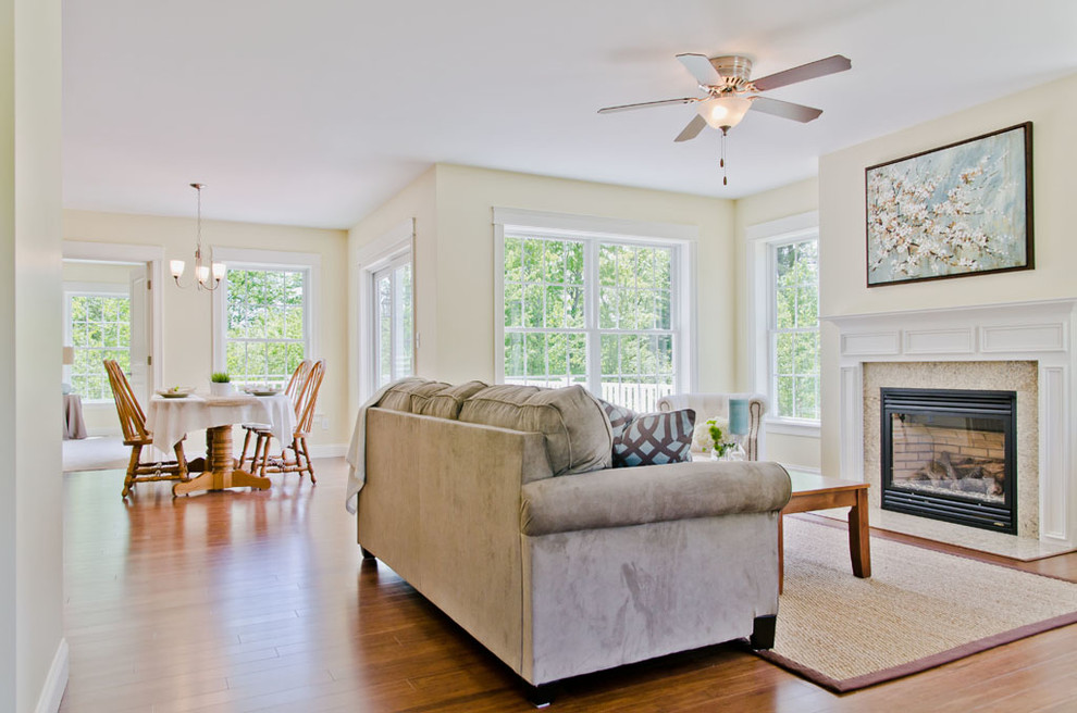 Mid-sized traditional formal enclosed living room in Portland Maine with yellow walls, medium hardwood floors, a standard fireplace, a tile fireplace surround and no tv.