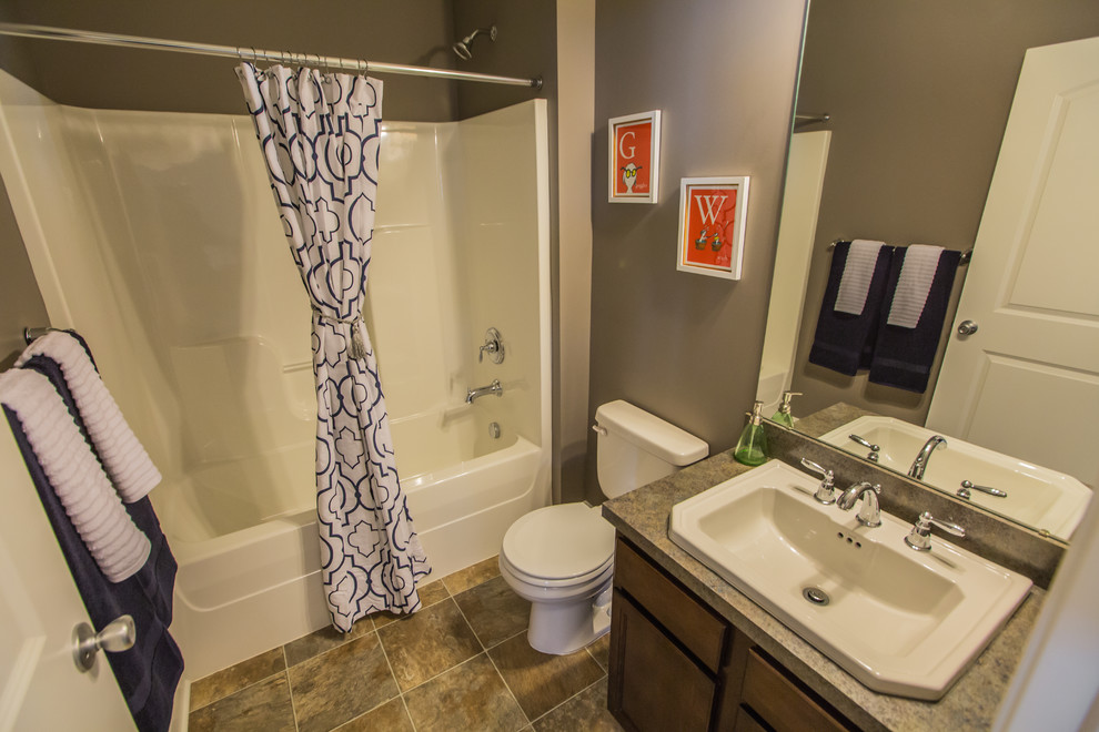 Design ideas for a small transitional bathroom in Philadelphia with a drop-in sink, shaker cabinets, medium wood cabinets, laminate benchtops, an alcove tub, a shower/bathtub combo, beige tile, beige walls, linoleum floors and a two-piece toilet.