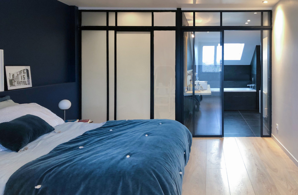 На фото: большая спальня на антресоли в современном стиле с синими стенами, светлым паркетным полом и черным полом без камина