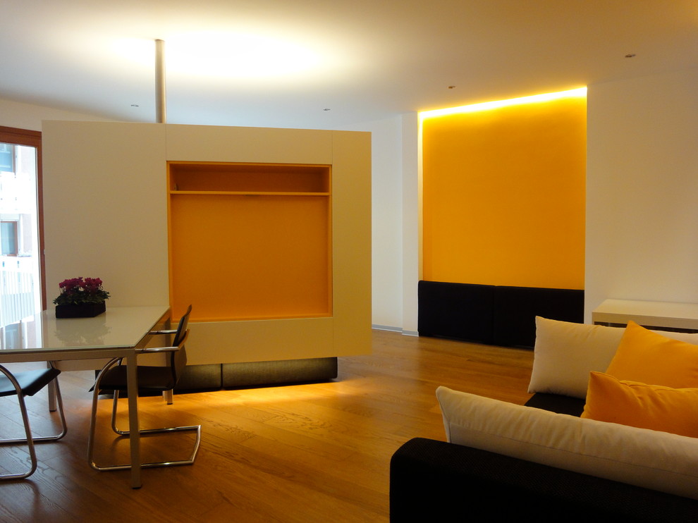 Photo of a contemporary living room in Venice with orange walls, painted wood floors and a built-in media wall.