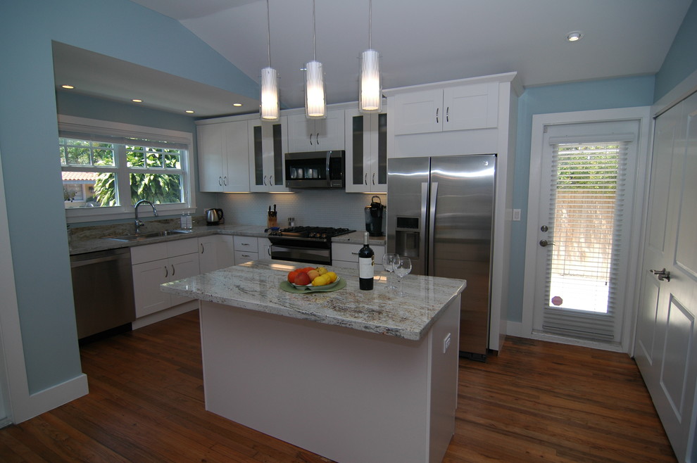 Design ideas for a transitional l-shaped kitchen in Miami with a double-bowl sink, shaker cabinets, white cabinets, granite benchtops, glass tile splashback, stainless steel appliances, medium hardwood floors and with island.