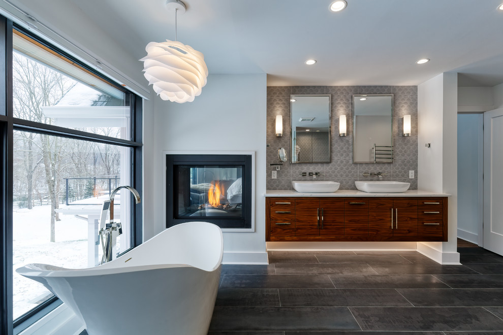 Design ideas for a large contemporary master bathroom in Cincinnati with flat-panel cabinets, a freestanding tub, a vessel sink, grey floor, dark wood cabinets, gray tile, white walls, white benchtops, a curbless shower, porcelain tile, porcelain floors and a hinged shower door.