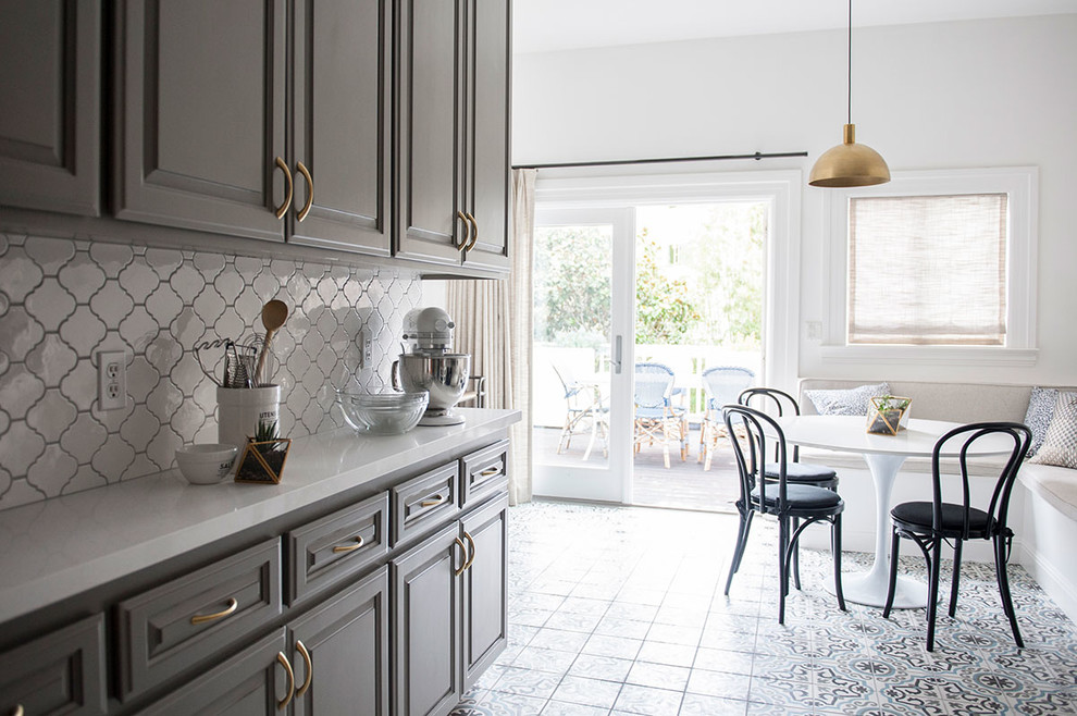 Small transitional galley eat-in kitchen in San Francisco with grey cabinets, white splashback, ceramic splashback, cement tiles, raised-panel cabinets, stainless steel appliances, no island, quartzite benchtops and multi-coloured floor.