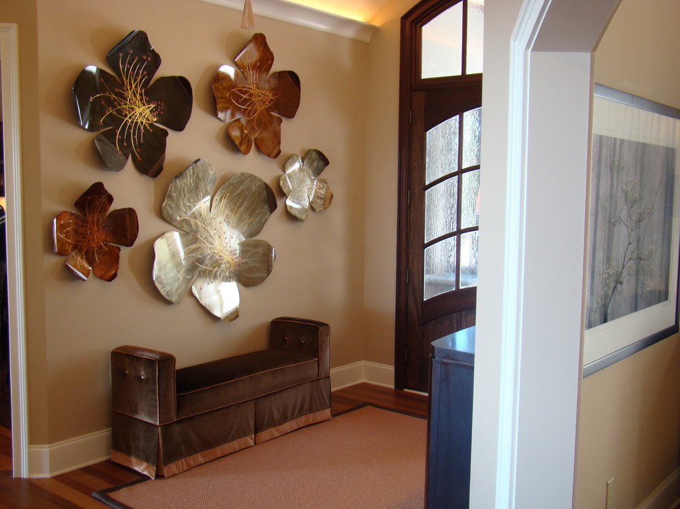 This is an example of a contemporary entry hall in Charlotte with beige walls and a dark wood front door.
