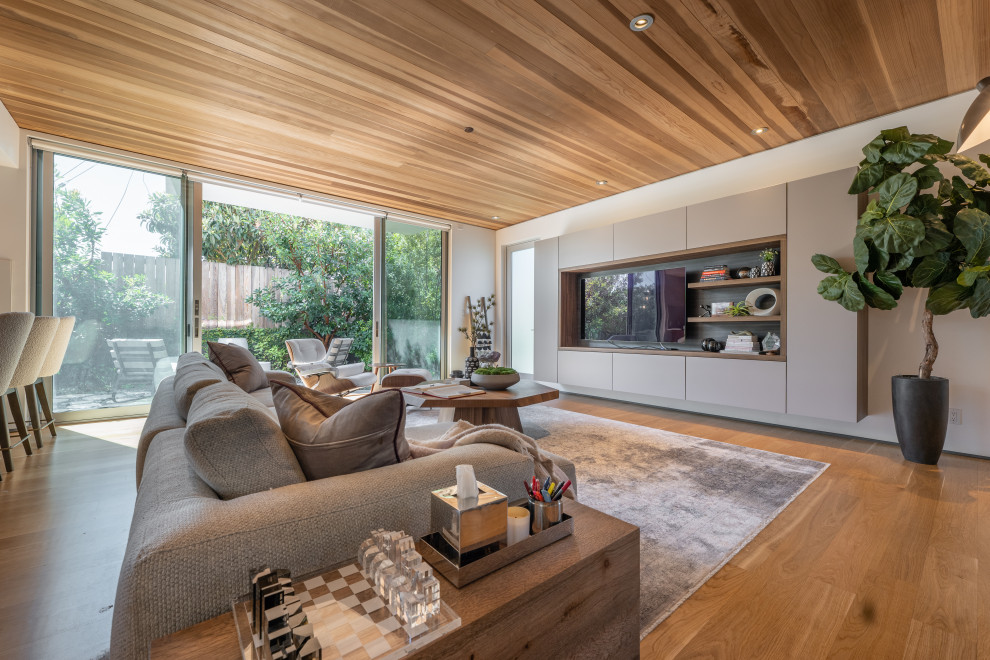Photo of a large contemporary formal open plan living room in Los Angeles with white walls, medium hardwood flooring, no fireplace, a built-in media unit and a wood ceiling.