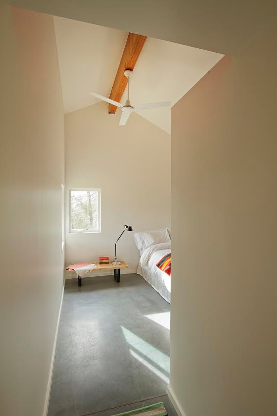 Mid-sized scandinavian loft-style bedroom in Other with beige walls, concrete floors, no fireplace and grey floor.