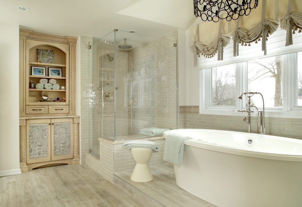 Immagine di una stanza da bagno padronale classica di medie dimensioni con consolle stile comò, ante con finitura invecchiata, vasca freestanding, piastrelle beige, piastrelle in ceramica, pareti beige, pavimento in gres porcellanato, lavabo sottopiano e top in granito