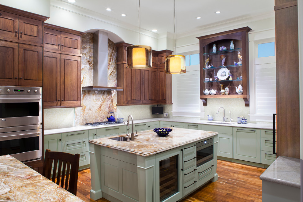 Transitional medium tone wood floor open concept kitchen photo in Jacksonville with an undermount sink, raised-panel cabinets, green cabinets, granite countertops, white backsplash, glass tile backsplash, stainless steel appliances and two islands