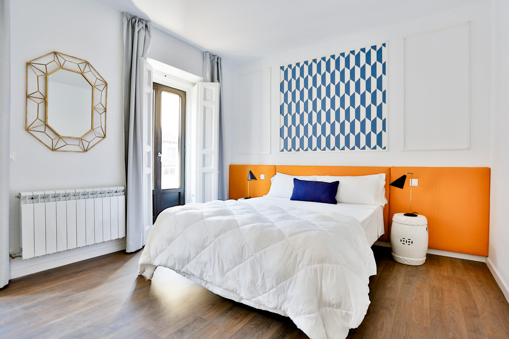 Inspiration for a mid-sized contemporary master bedroom in Madrid with white walls, medium hardwood floors and no fireplace.