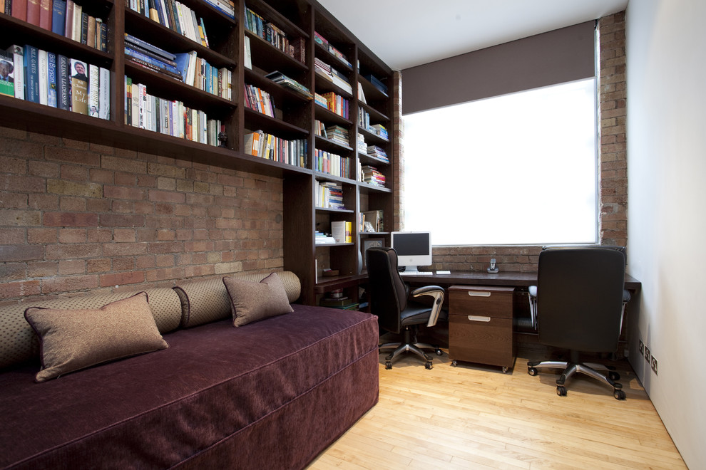 Photo of a contemporary home office in London with light hardwood floors and a built-in desk.