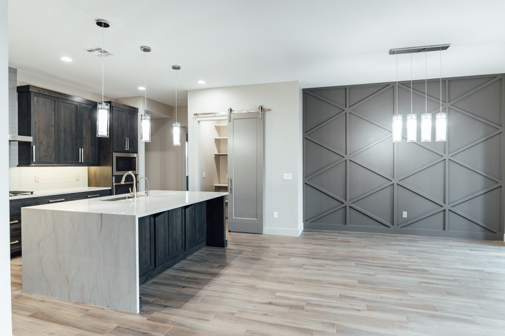 Modern kitchen/dining combo in Salt Lake City with grey walls, ceramic floors, a standard fireplace, a wood fireplace surround, brown floor, coffered and wood walls.