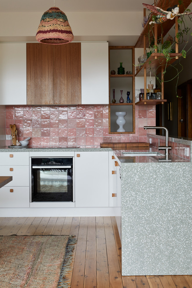 Modelo de cocinas en L pequeña con armarios con paneles lisos, puertas de armario blancas, encimera de terrazo, salpicadero rosa y encimeras verdes
