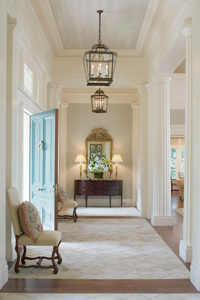 This is an example of a traditional entryway in Atlanta with a blue front door and beige floor.