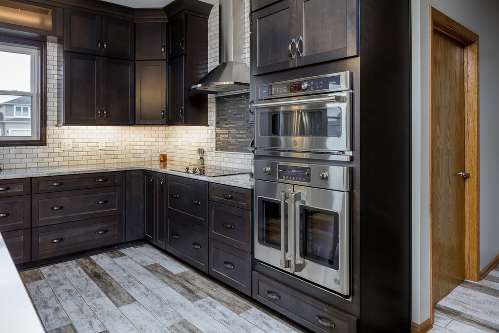 Mid-sized transitional l-shaped ceramic tile and multicolored floor eat-in kitchen photo with an undermount sink, shaker cabinets, medium tone wood cabinets, quartz countertops, white backsplash, marble backsplash, stainless steel appliances, an island and white countertops