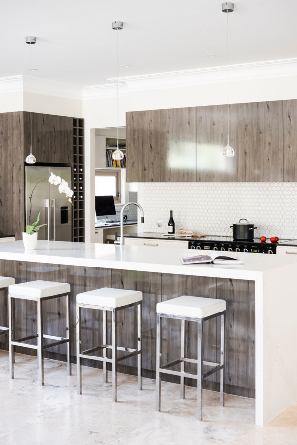 Inspiration for an expansive modern l-shaped open plan kitchen in Melbourne with an undermount sink, flat-panel cabinets, light wood cabinets, quartz benchtops, white splashback, mosaic tile splashback, black appliances, marble floors, with island and pink floor.
