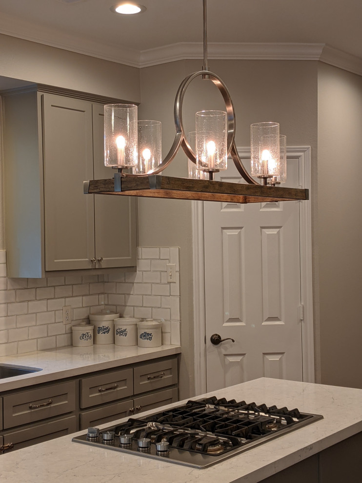 Mid-sized transitional galley medium tone wood floor and brown floor eat-in kitchen photo in Houston with shaker cabinets, gray cabinets, quartz countertops, white backsplash, subway tile backsplash, an island and white countertops
