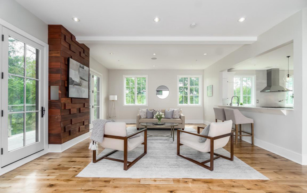 Example of a trendy open concept light wood floor and brown floor living room design in DC Metro with white walls