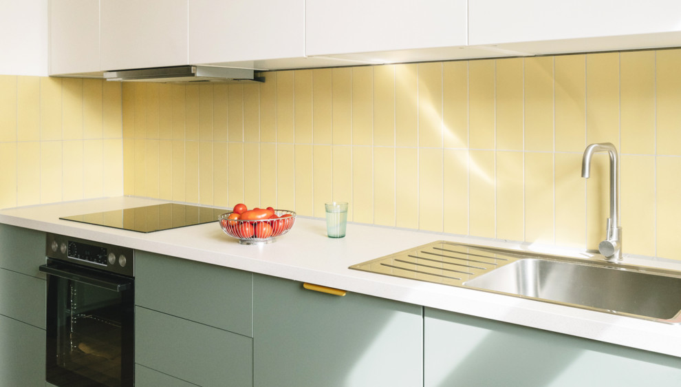 Offene, Einzeilige, Mittelgroße Moderne Küche mit grünen Schränken, Küchenrückwand in Gelb, Rückwand aus Metrofliesen und weißer Arbeitsplatte in Berlin