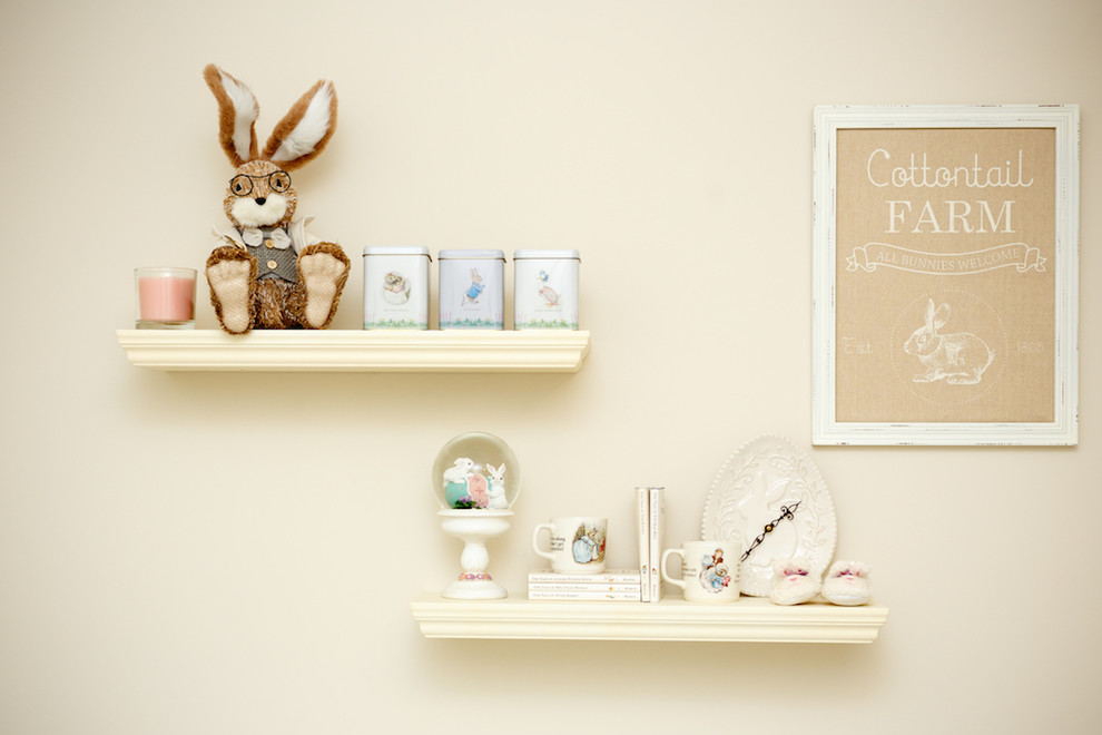 Example of a mid-sized transitional girl dark wood floor nursery design with beige walls