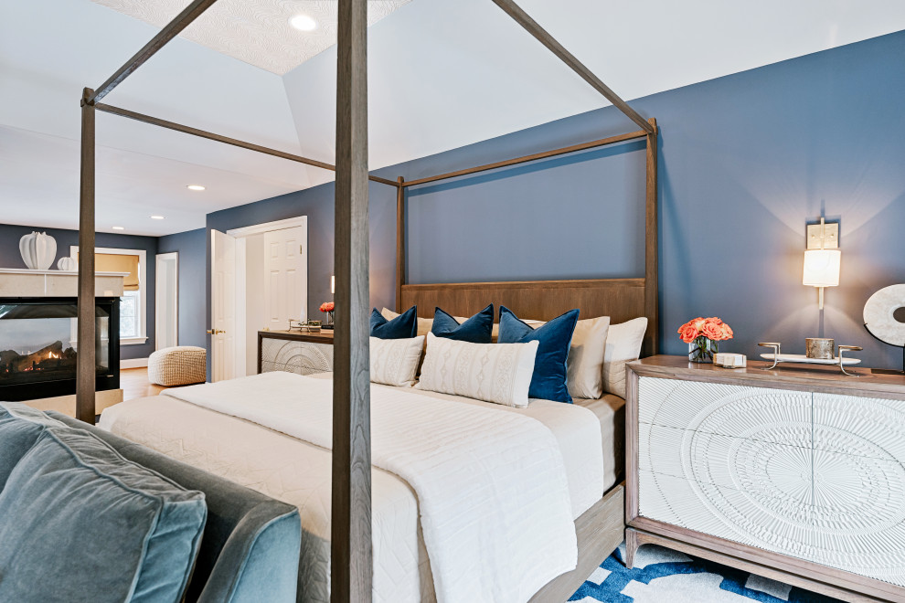 Cette photo montre une chambre parentale chic avec un mur bleu, un sol en bois brun, aucune cheminée, un sol marron et un plafond décaissé.
