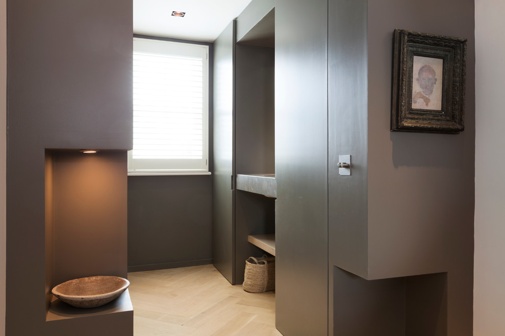 Design ideas for a mid-sized modern powder room in London with a wall-mount sink, open cabinets, medium wood cabinets, wood benchtops, grey walls and medium hardwood floors.