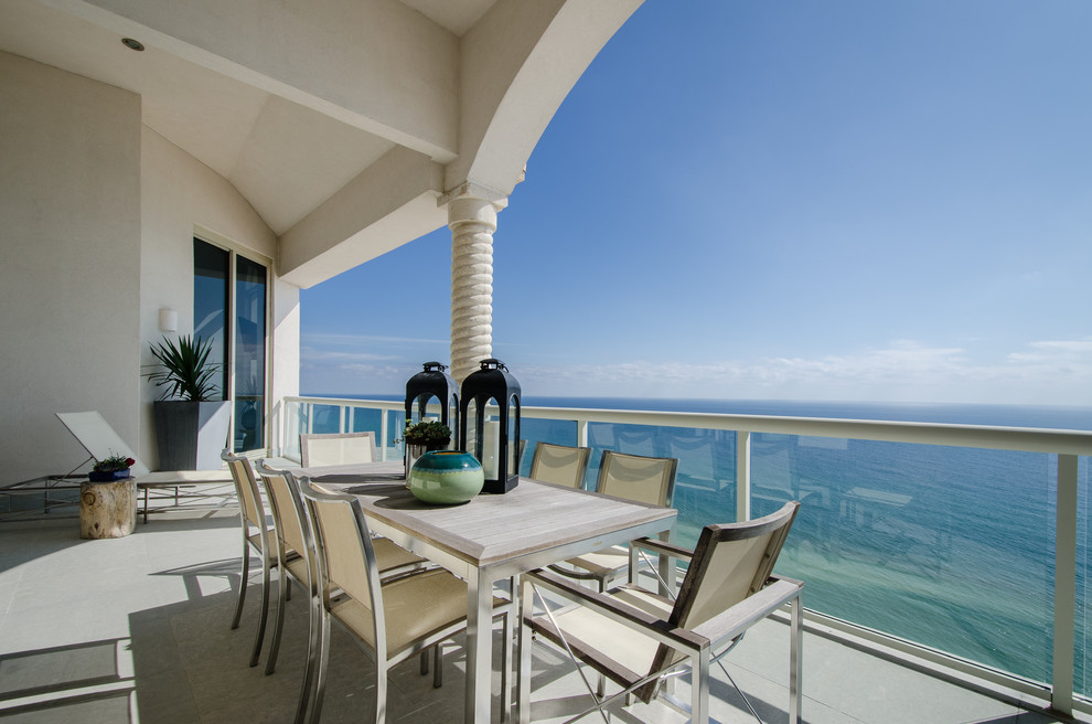 Photo of a beach style balcony in Miami with a roof extension.