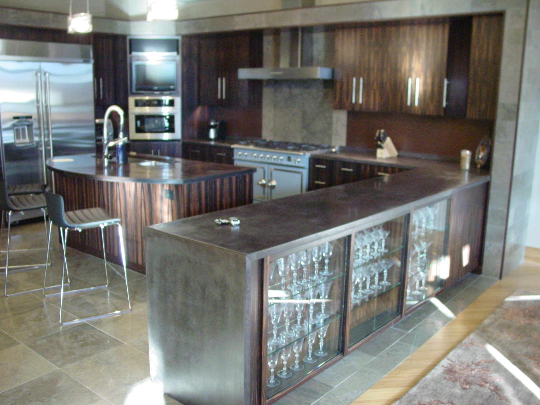 Black concrete countertops with exotic wood cabinets, stainless steel appliances