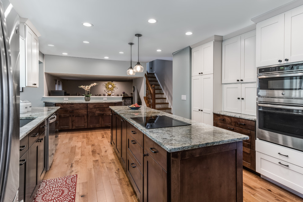 Mid-sized transitional galley medium tone wood floor and brown floor eat-in kitchen photo in Denver with an undermount sink, shaker cabinets, white cabinets, granite countertops, blue backsplash, glass tile backsplash, stainless steel appliances, an island and beige countertops