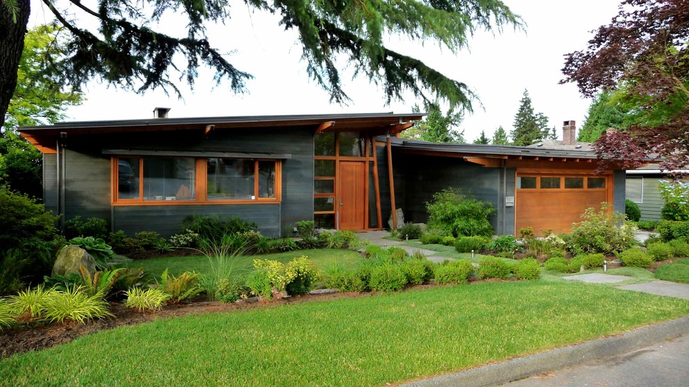 Small midcentury one-storey grey exterior in Vancouver with a shed roof.
