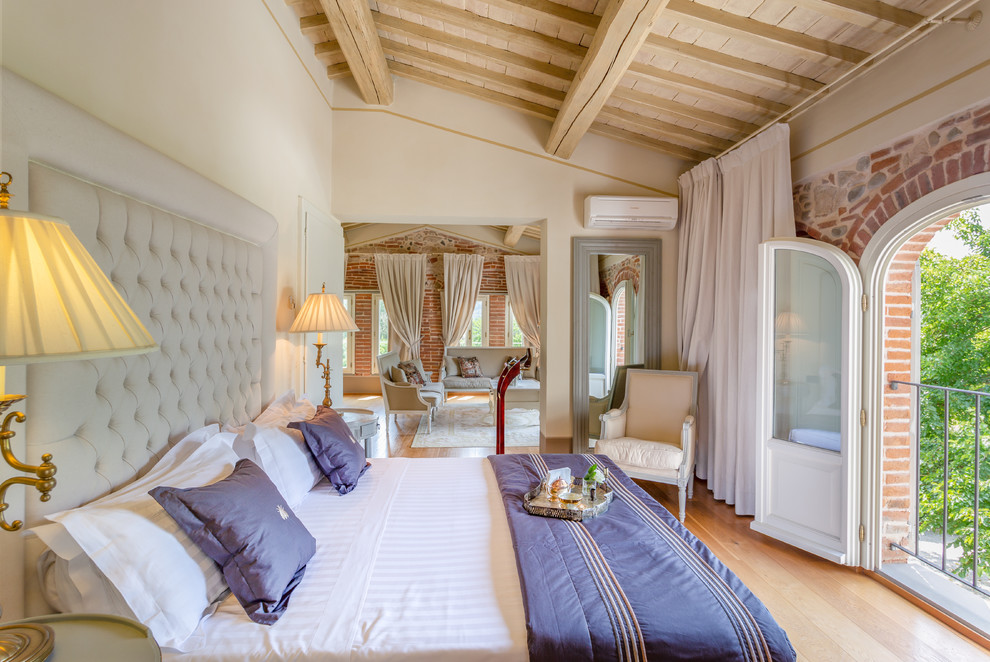 This is an example of a traditional bedroom in Florence with beige walls, light hardwood floors and beige floor.