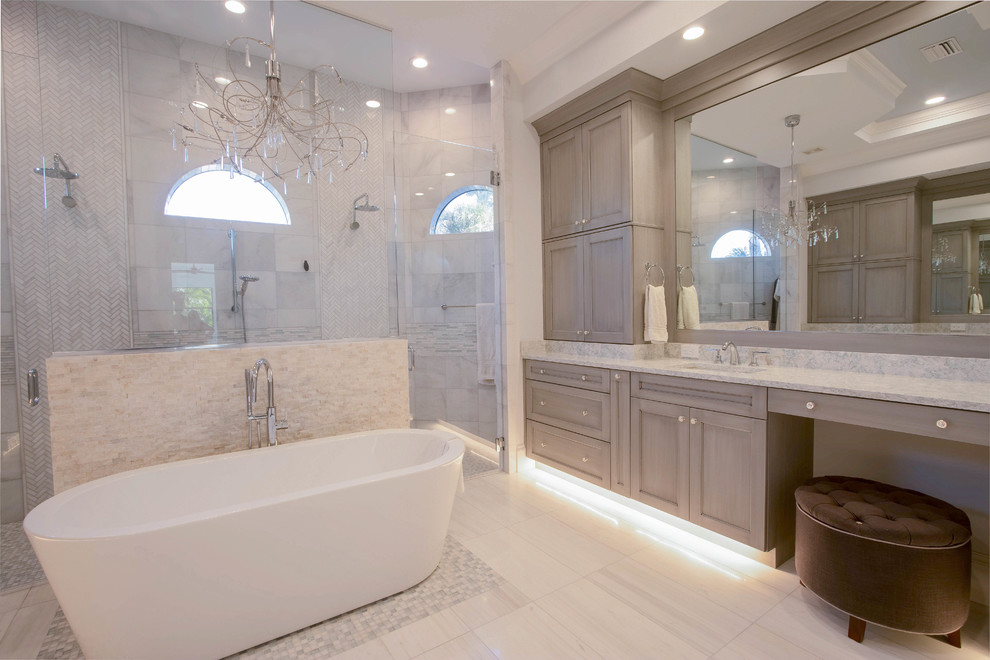 Huge transitional master white tile and porcelain tile porcelain tile and white floor freestanding bathtub photo with shaker cabinets, gray cabinets, a two-piece toilet, gray walls, an undermount sink, quartz countertops and a hinged shower door