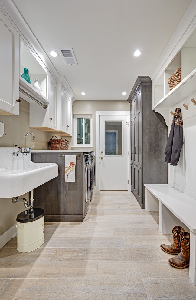 Design ideas for a mid-sized country galley utility room in Sacramento with a farmhouse sink, recessed-panel cabinets, white cabinets, quartz benchtops, beige walls, porcelain floors and a side-by-side washer and dryer.