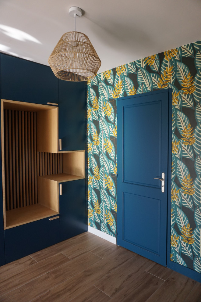 Photo of a small traditional entrance in Toulouse with multi-coloured walls, ceramic flooring, a single front door, a blue front door, beige floors and wallpapered walls.